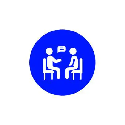 Two people having a conversation while seated at a table.
