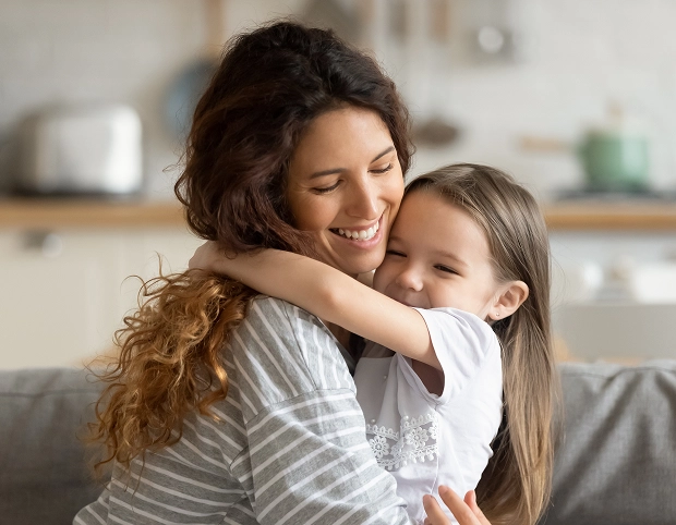 Mother and daughter sharing a warm hug indoors.